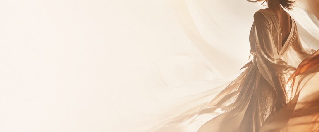 Fashion editorial of a model in a flowing cream dress